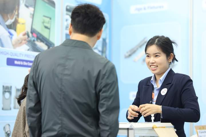 CAM Resources representative interacts with a visitor at a trade expo